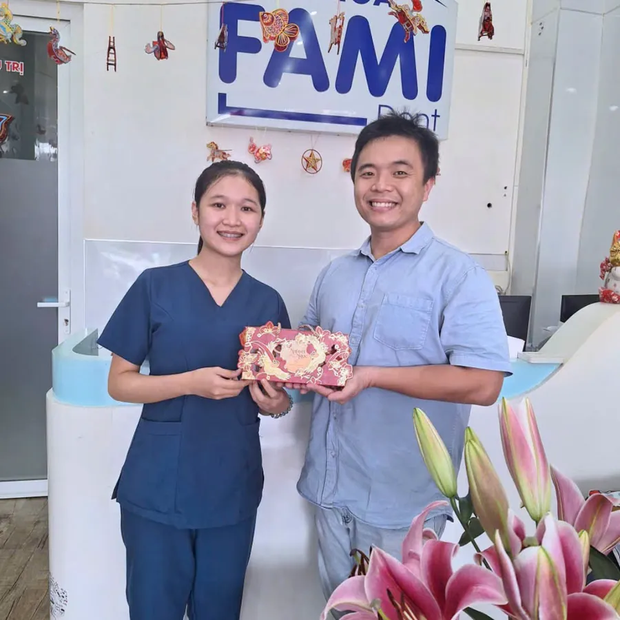 Nhân viên Fami Dent và bác sĩ cầm hộp quà